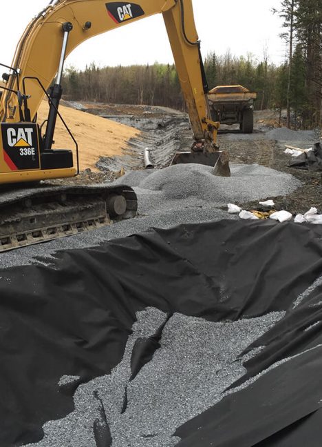 mechanical shovels installing crushed stone over nonwoven geotextile