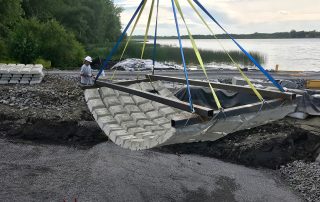 articulated concrete mat being installed with home-made spreader-bar